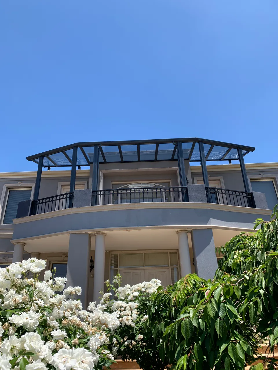 Full property view showing the scale and upper-level position of the transparent patio roof