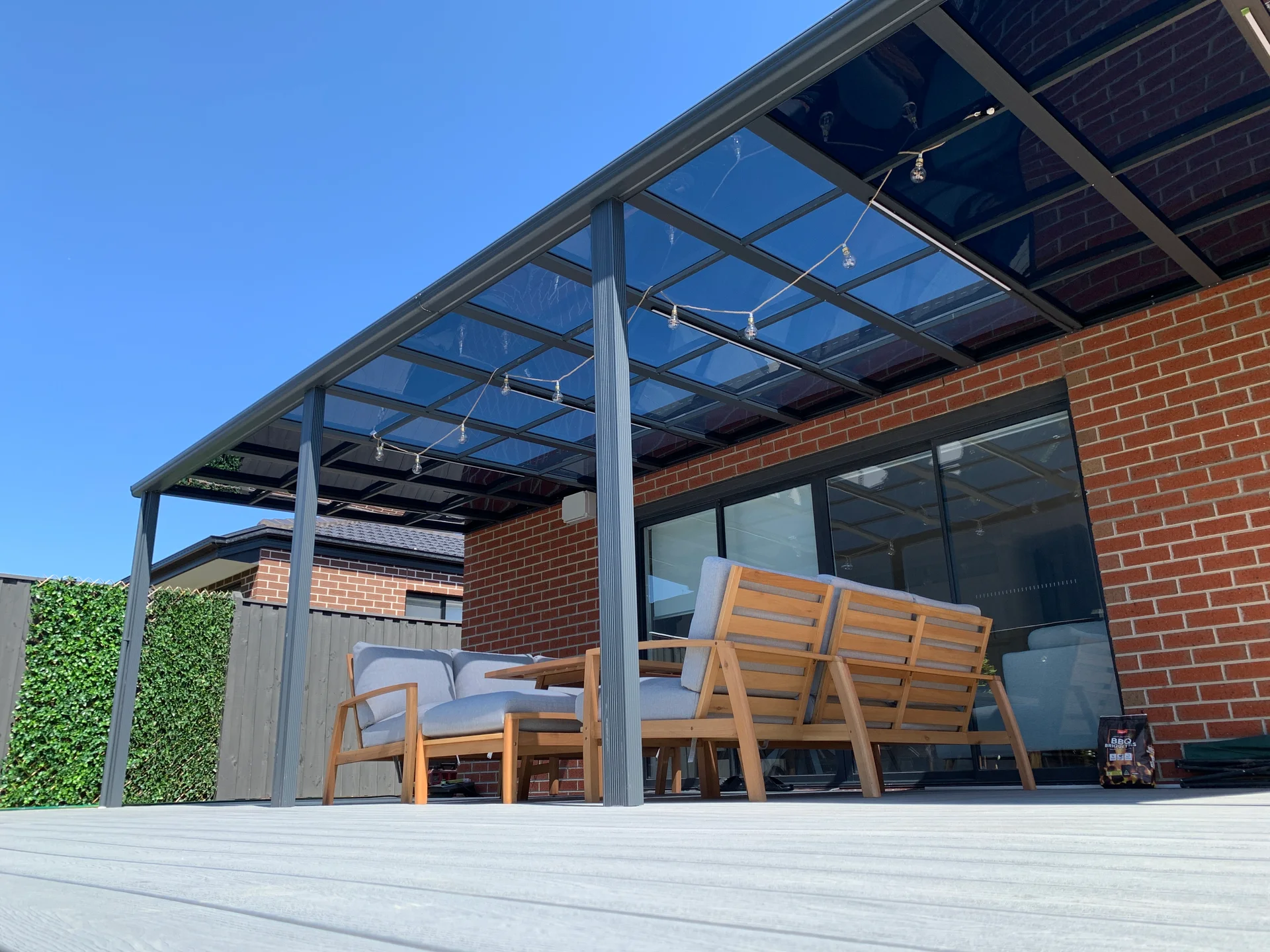Clearview patio roof and outdoor seating beside a brick home in Keysborough