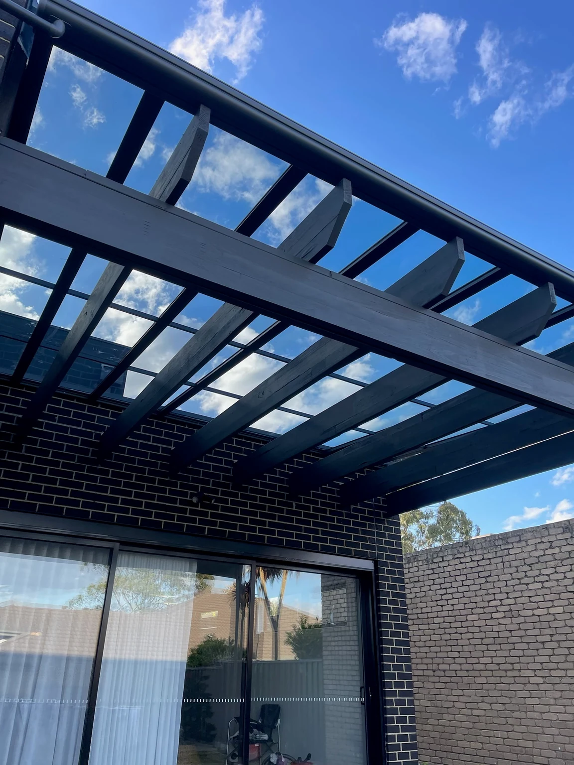 Full view of the same pergola after Clearview transparent roofing was added above